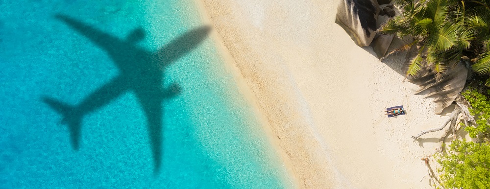 Travel insurance quote - image of plane flying over beach